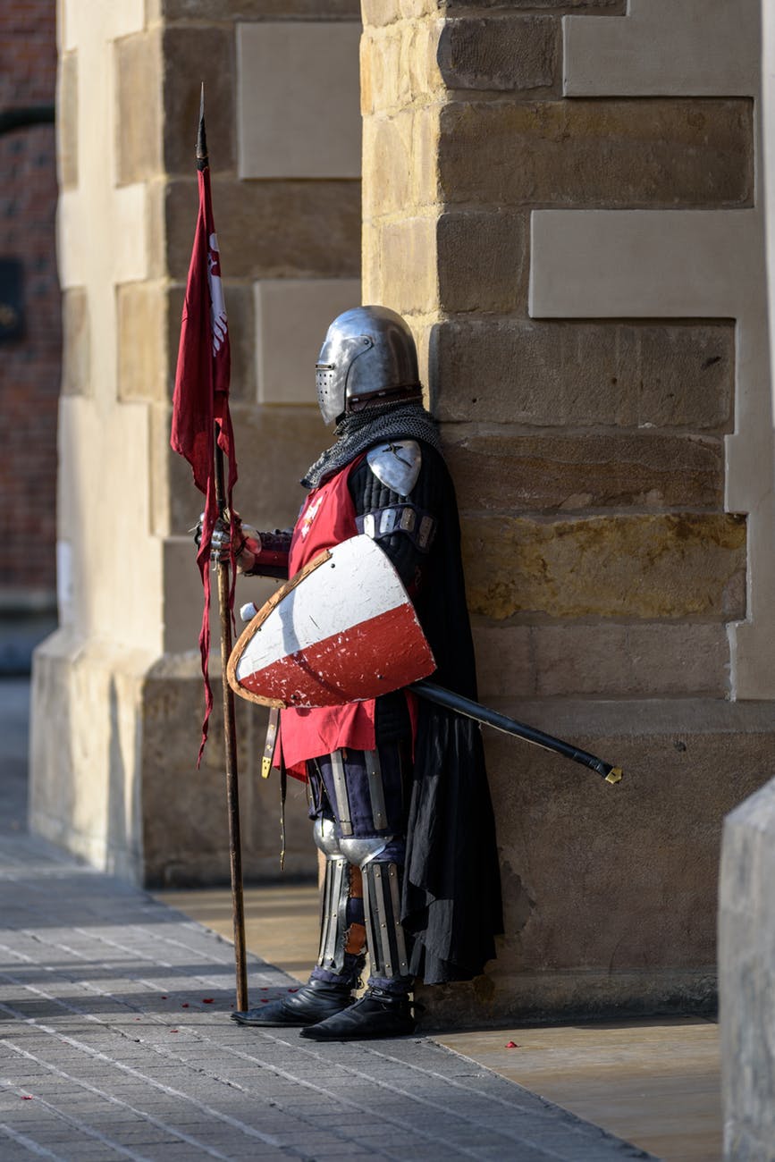 man wearing gray and red armour standing on the streets